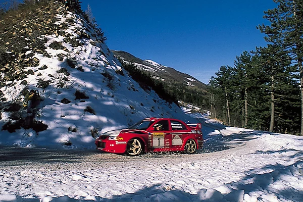 Red Evo rally car on snowy rally stage