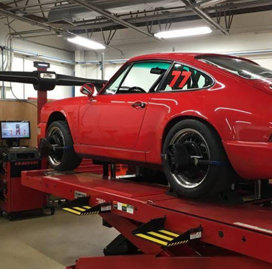 Red Porsche 964 Elevated on a Lift for Wheel Alignment